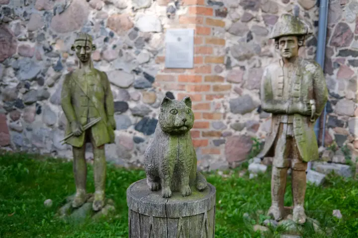 Die Sage vom Trommler aus Gröben, Schnitzfiguren vor der Kirche Gröben