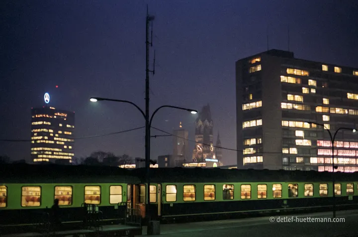 D-Zug im Bahnhof Zoo, dahinter Europa-Center und Gedächtniskirche bei Nacht