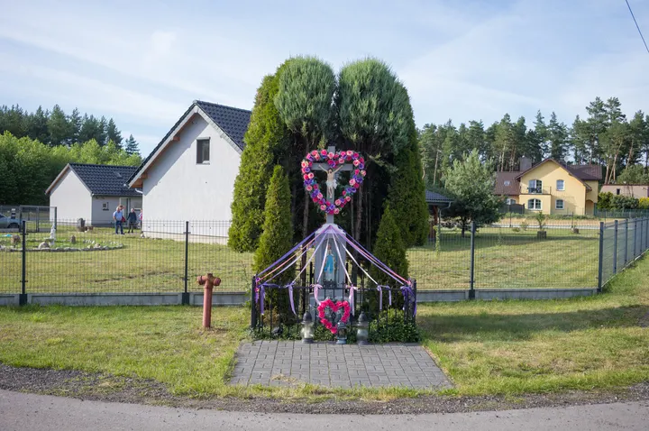 Christliches Wegekreuz mit Girlanden und Blumenschmuck in Tanina