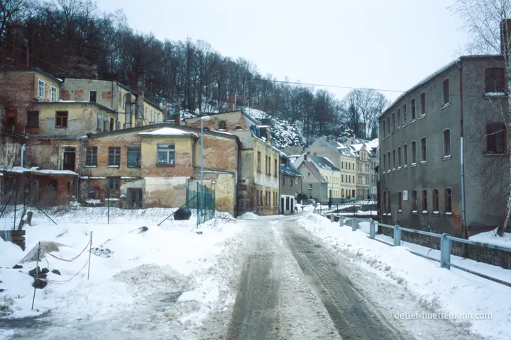 Verfallende Häuser an einer verschneiten Straße