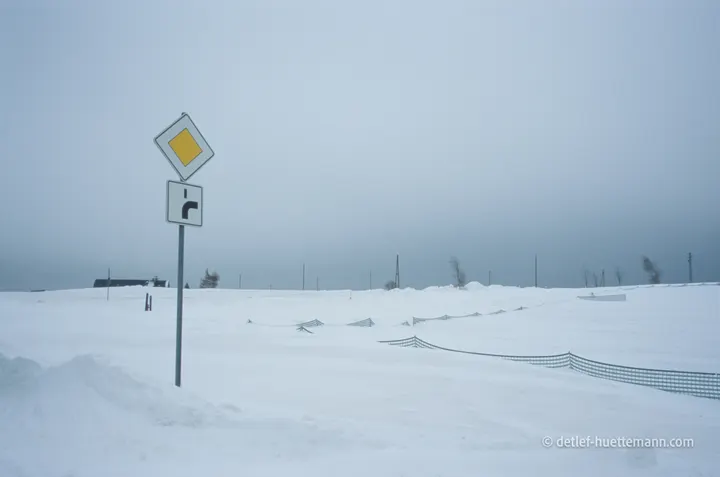 Vorfahrtsschild an der unter Schnee verschwundenen Straße