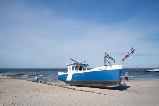 Blau-weißer Fischkutter NIE 15 auf dem Strand