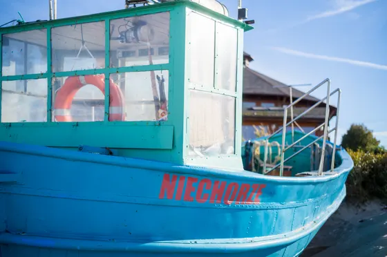 Türkisfarbenes Fischerboot mit roter Aufschrift Niechorze