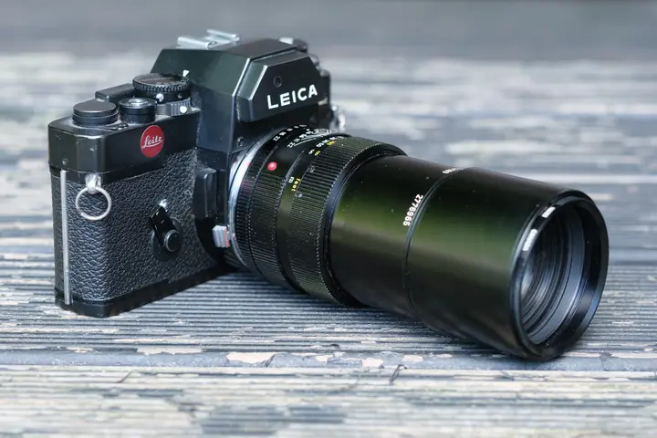 Leica R3 mit angesetztem APO-Telyt-R 180 mm f/3,4 auf einem verwitterten Holztisch