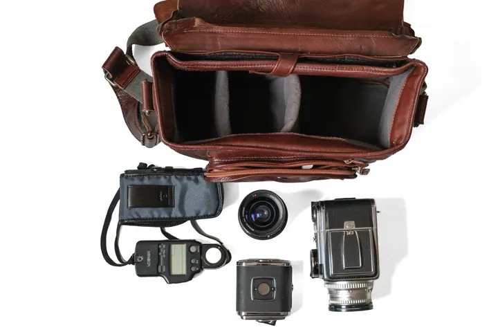 Geöffneter Compagnon Medium Messenger, davor Hasselblad 500C/M, ein zweites Magazin, ein Objektiv und ein Belichtungsmesser