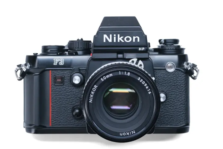 Nikon F3HP von vorn mit Nikkor 50 mm f/1,8: Griffwulst mit roter Linie, F3-Schriftzug und Prismensucher mit HP-Kennzeichnung