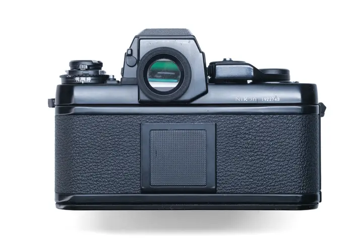 Rückseite der Nikon F3HP mit dem großen runden Okular des High-Eyepoint-Suchers, daneben die Filmempfindlichkeitsskala und auf der Rückwand der Halter für die Lasche der Filmschachtel